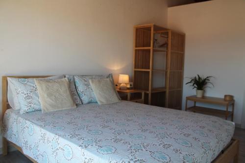 a bedroom with a large bed with blue and white sheets at b&b U Punenti in La Maddalena