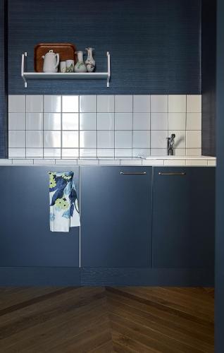 a kitchen with blue and white tiles and a sink at Hotelli Vihannonkulma in Loimaa