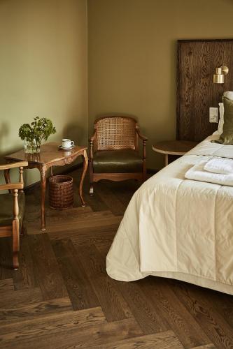 a bedroom with a bed and a table and a chair at Hotelli Vihannonkulma in Loimaa