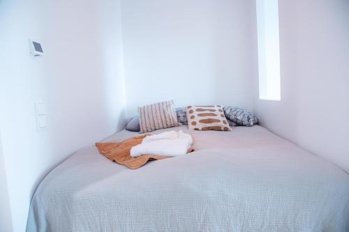 a bed in a white room with towels on it at Huoneisto Tampereen paraatipaikalla. 14. kerros. in Tampere