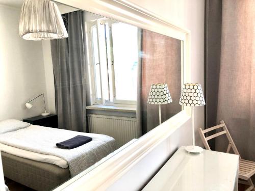 a small bedroom with a bed and a window at Scandinavian apartments Heart of the city Kamppi 1, 5, 6 in Helsinki