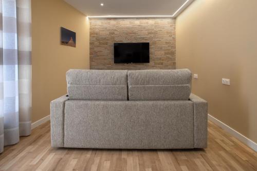 a couch in a living room with a fireplace at Apartamentos La Jasa in Arguedas