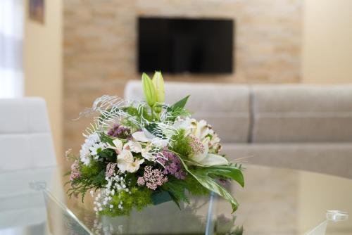 a bouquet of flowers sitting on a glass table at Apartamentos La Jasa in Arguedas