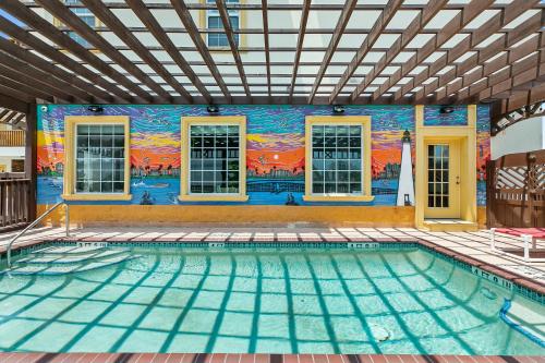 a swimming pool with a mural on the side of a house at Lighthouse Inn in South Padre Island