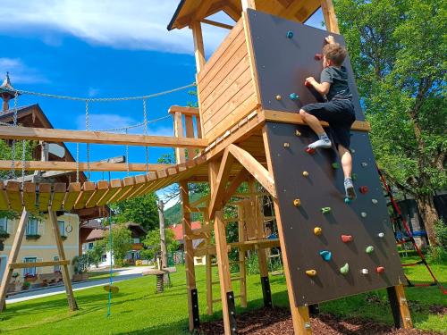 a boy on a climbing wall at a playground at Biohof Untergrabenbauer in Lidaun