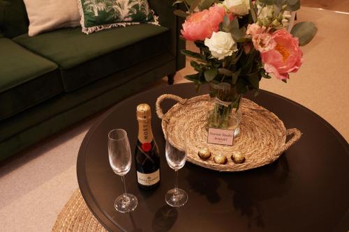 a table with a vase of flowers and two wine glasses at Norton Studio in Arundel