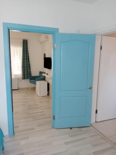 a room with a blue door and a living room at Daffne Otel in Canakkale