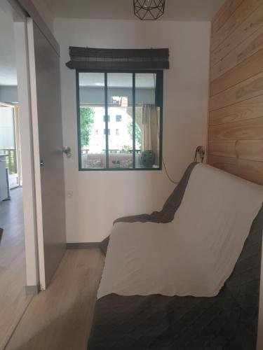 1 dormitorio con cama y ventana. en Magnifique studio, centre, parking privée,terrasse en Le Monêtier-les-Bains