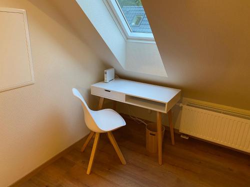 a desk and a chair in a room with a window at Ferienhäuser Zinke in Krauschwitz
