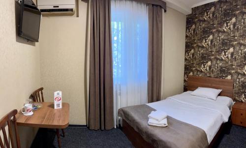 a hotel room with a bed and a table and a window at Hotel LaMa 2 in Kyiv