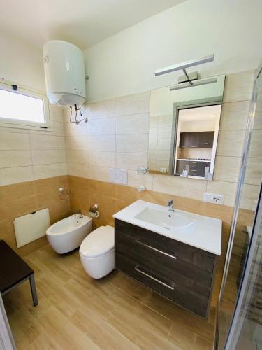 a bathroom with a sink and a toilet and a mirror at Marasusa Sunset in Parghelia