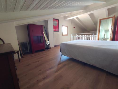 a bedroom with a large bed and a wooden floor at Gnazzano Home 1 in Loiano