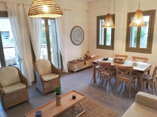 a living room with a dining room table and chairs at Nautilus Beach Home in Platanidia