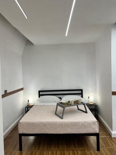 Cette chambre blanche dispose d'un lit avec une table. dans l'établissement La Cupola, à Naples