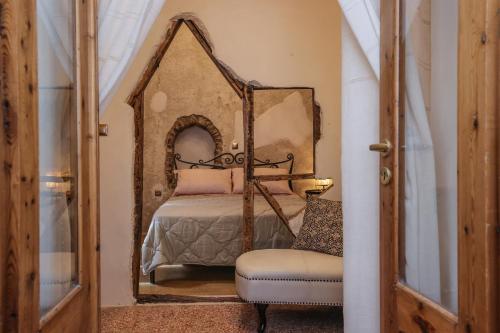 a bedroom with a bed with a mirror and a chair at SIKATE Hospitality in Mýkonos City