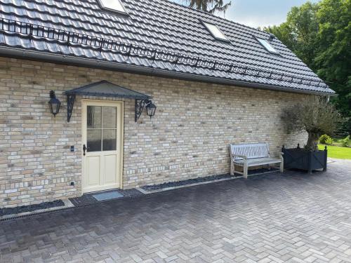 a brick building with a bench next to a door at Ferienhäuser Zinke in Krauschwitz