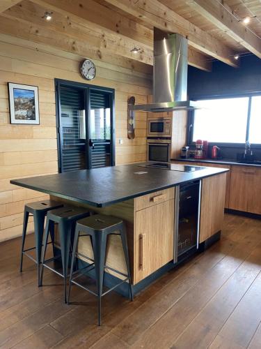 a kitchen with a large island with black counter top at Chalet Montagne in Saint-Pastous