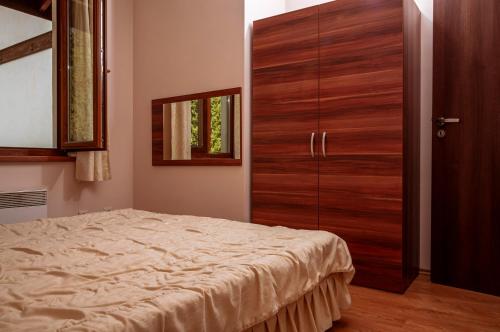 a bedroom with a wooden closet and a bed at Stand'Art - апартамент , Смолянски езера in Smolyan