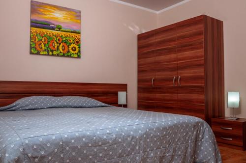 a bedroom with a bed and a painting on the wall at Stand'Art - апартамент , Смолянски езера in Smolyan