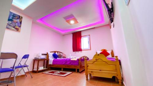 a bedroom with a bed and a purple ceiling at Hotel EL MARSA LA PLAYA in Laayoune