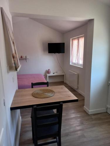 um quarto com uma mesa e um quarto com uma cama em COQUETTE MAISONNETTE em Bourges