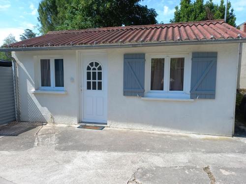 une petite maison blanche avec un toit rouge dans l'établissement COQUETTE MAISONNETTE, à Bourges