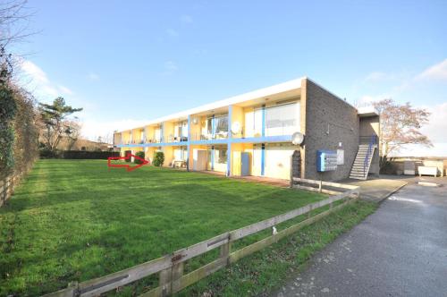 a building with a large yard in front of it at Vakantiehuisje Martina 18 in Vlissingen
