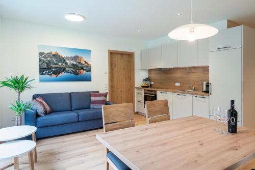 eine Küche und ein Wohnzimmer mit einem blauen Sofa in der Unterkunft Apartment Fitsch in Silbertal