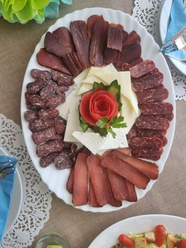 a plate of meats and cheese on a table at Семеен хотел При Вергил in Sapareva Banya