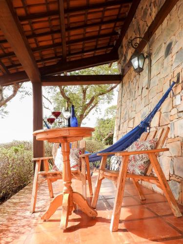 a table and a hammock on a patio at Pousada Recanto do Turvo in Capitólio