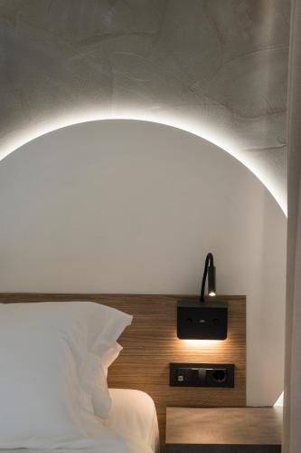 a bedroom with a white bed with an arch above it at Alkionides Seaside Hotel in Plataniás