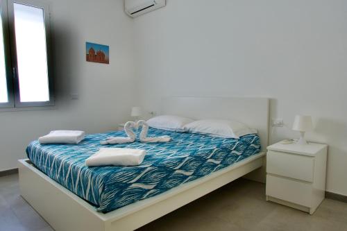 マリーナ・ディ・ラグーザにあるVilla Carolinaのベッドルーム1室(白鳥2羽のベッド1台付)