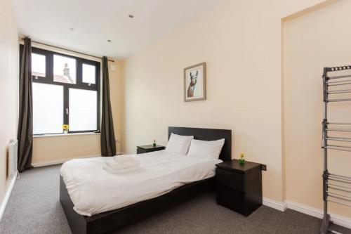 a bedroom with a large bed and a large window at Stylish 2 Bedroom Apartment in Greenwich in London