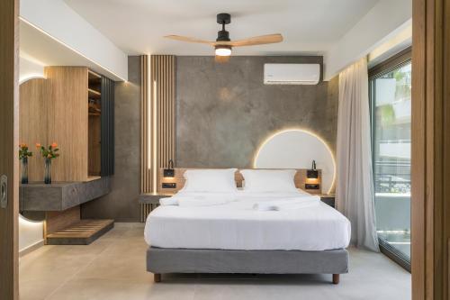 a bedroom with a bed and a ceiling fan at Alkionides Seaside Hotel in Plataniás