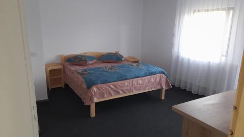 um quarto com uma cama com lençóis azuis e uma janela em Casa Catalin em Gura Humorului