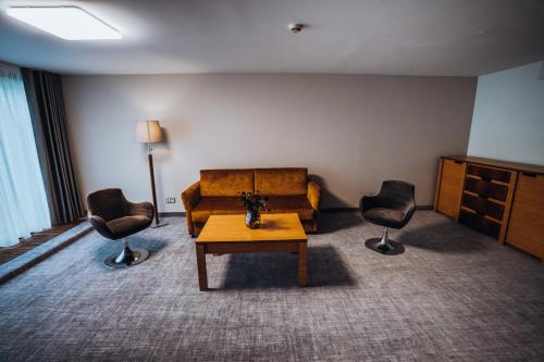 a living room with a couch and two chairs at Gabija Hotel SPA & Conferences in Palanga