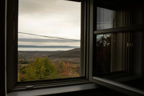 a window with a view of a field and trees at Kiskacsa Nyúlontúl in Mencshely