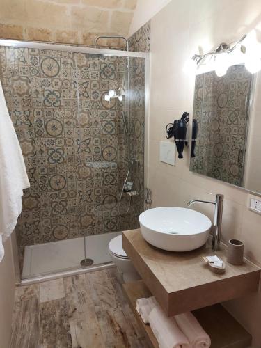W łazience znajduje się umywalka, toaleta i prysznic. w obiekcie Il Vicolo Grottaglie w mieście Grottaglie