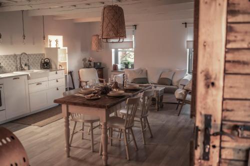 a kitchen and living room with a table and chairs at Kiskacsa Nyúlontúl in Mencshely