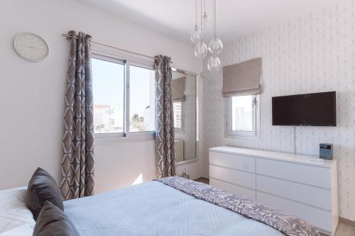 a bedroom with a bed and a flat screen tv at Villa Aquamarine in Paphos City