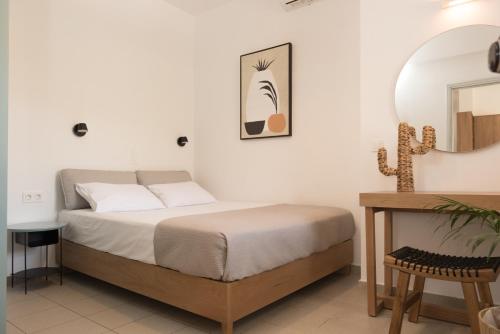 1 dormitorio con cama, espejo y mesa en eden of grameno, en Palaiochóra