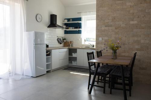 een keuken met een tafel en stoelen en een koelkast bij Dom pod Sitnom in Banská Štiavnica