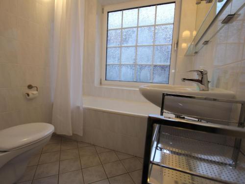 a bathroom with a sink and a toilet and a window at Ferienwohnung in Westerland auf Sylt in Westerland (Sylt)