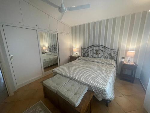 ein kleines Schlafzimmer mit einem Bett und einem Spiegel in der Unterkunft Casa vacanze Sant'Antioco in SantʼAntìoco