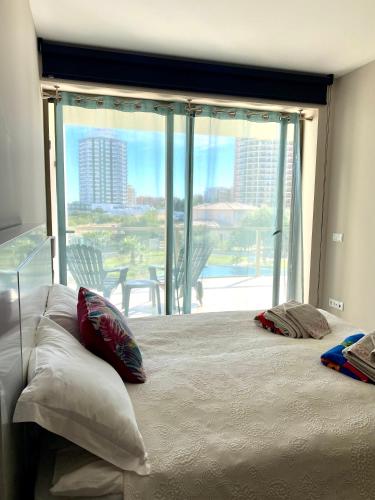 a bedroom with a large bed with a large window at NEW STUNNING OCEAN APRT IN "OASIS MAR" Wi-Fi in Portimão