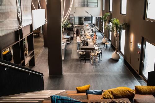 a person walking through a room with tables and chairs at Ariv Apartments & Spaces - self check-in in Basel