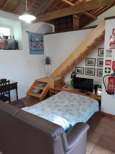 a room with a bed and a couch and a desk at Casa da Fonte in Angra do Heroísmo