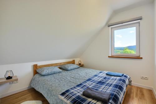 Schlafzimmer mit einem Bett und einem Fenster in der Unterkunft Domki Potok - Noclegi Bieszczady in Stefkowa