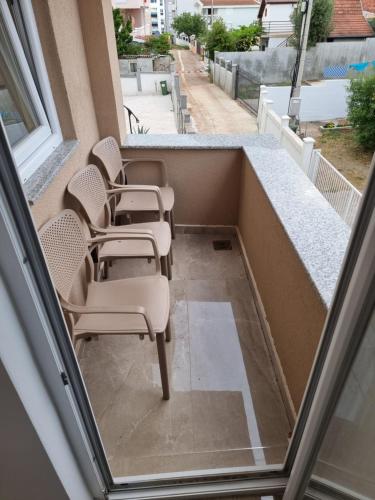 a row of chairs sitting on a balcony at Ebra Lux Apartmani in Dobra Voda
