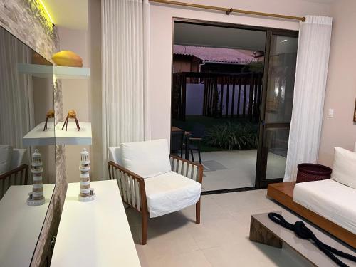 a living room with a couch and a table at Maiorca - Mar & Lazer 3 suítes Itacimirim pé na ar in Itacimirim